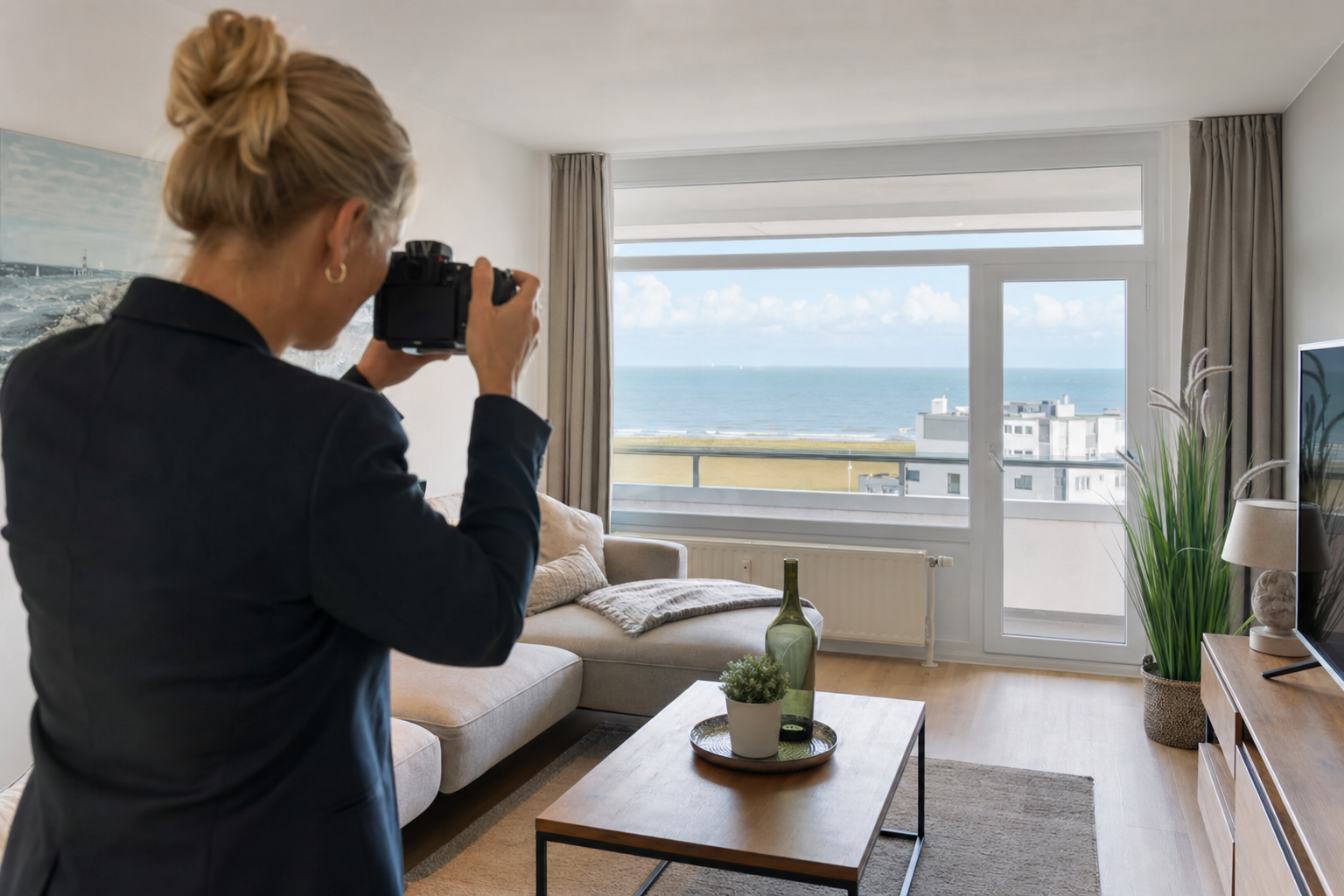 Makler fotografiert eine modern eingerichtete Wohnung mit Blick auf die Nordsee